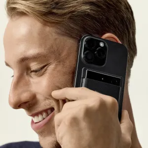 PLAUD Note Pro voice recorder held to a person’s ear, showing the compact black magnetic design