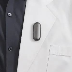 Enregistreur vocal IA PLAUD NotePin à clipser, porté sur le revers d’une veste en gris cosmique