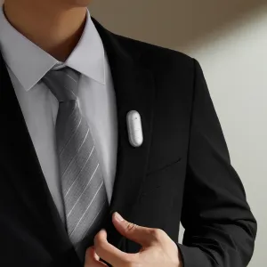 Enregistreur vocal PLAUD NotePin S fixé au revers d’un costume, présenté comme un appareil portable blanc compact