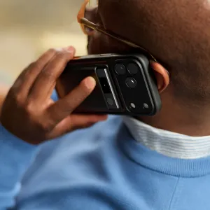 Grabadora de voz con IA PLAUD Note Pro negra sujeta a un smartphone durante una llamada telefónica