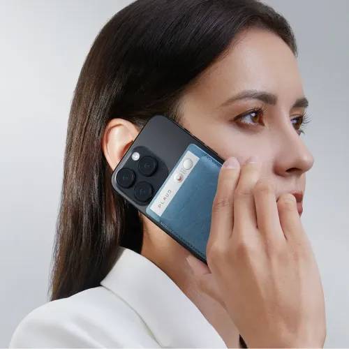 PLAUD NOTE hellblaues Magnet-Case mit Nähten, auf einem am schwarzen Handy befestigten Recorder montiert, Nahaufnahme am Ohr mit sichtbarer Taste.