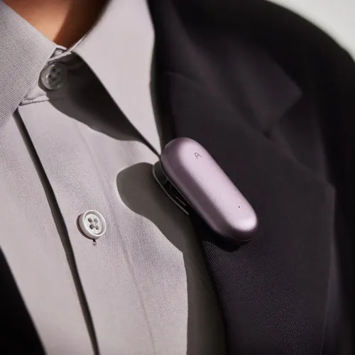 PLAUD NotePin Sunset Purple wearable AI voice recorder clipped to a shirt lapel