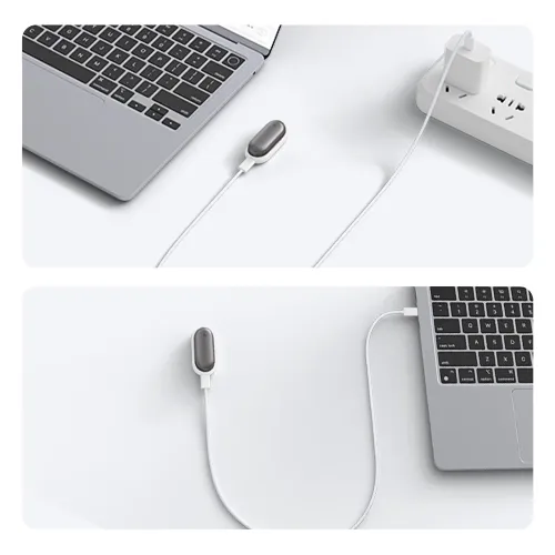 Magnetische Ladestation mit grauer Oberseite und geflochtenem USB-C-zu-USB-C-Kabel, verbunden mit einem Laptop und einer desktop-Steckdose.